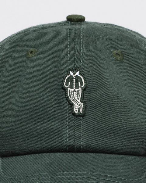 Green cap with an embroidered owl design on a white background