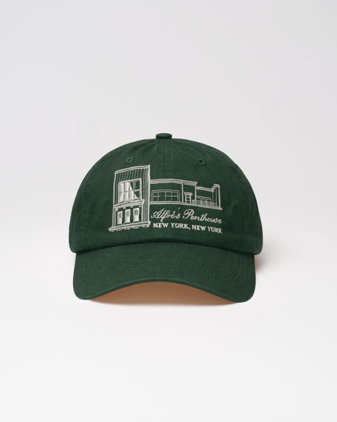 Green cap with white embroidery on a light gray background