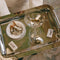Vintage-style silver tray with martini glass, olives, ashtray with cigarettes, and matchbox, evoking a classic luxury atmosphere.