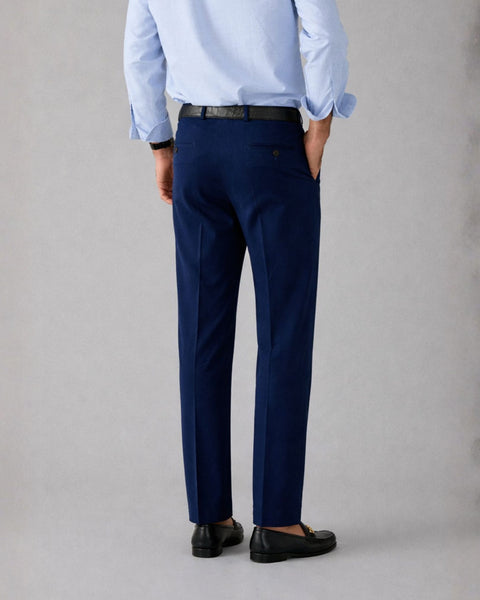 Person wearing a light blue shirt and navy pants on a gray background