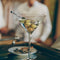 Martini glass with a cocktail on a bar counter, blurred background