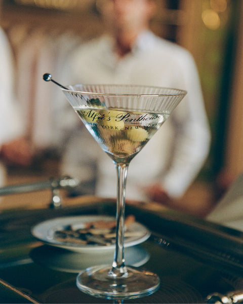 Martini glass with a cocktail on a bar counter, blurred background